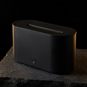 Three-quarter angle of the FlameMist diffuser showing its oval body and single button